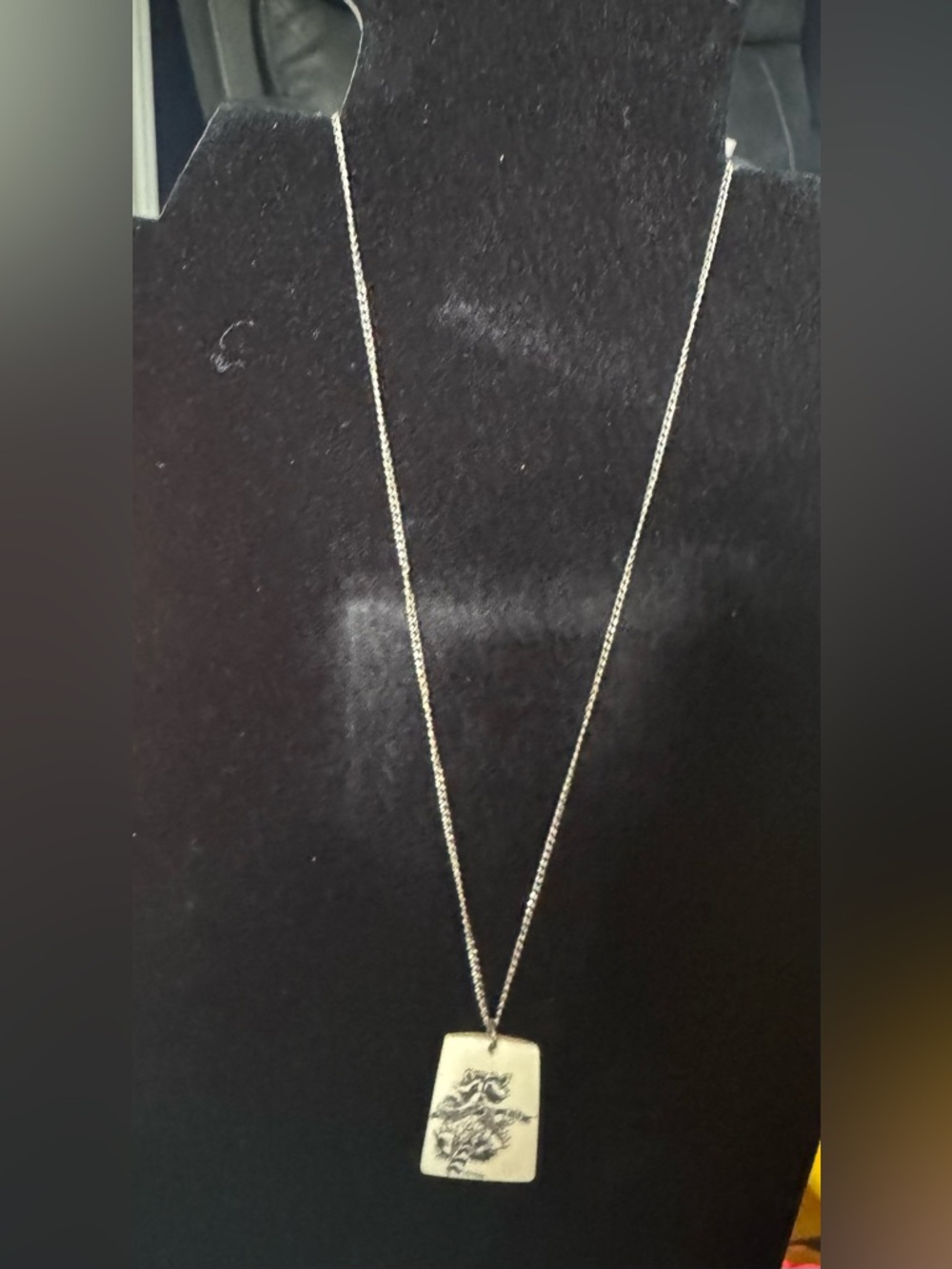 Collectible pendant featuring a scrimshaw-style in drawing of a racoon